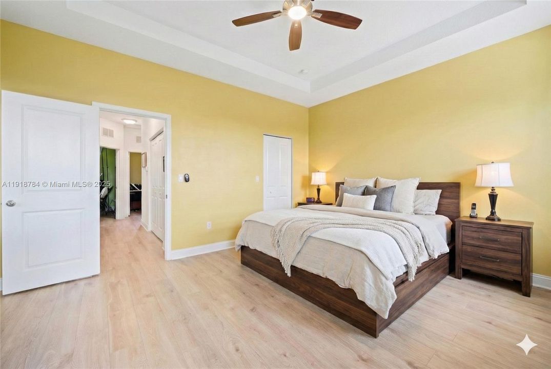 Large primary suite with abundant natural light, virtually decluttered and staged to highlight layout and space