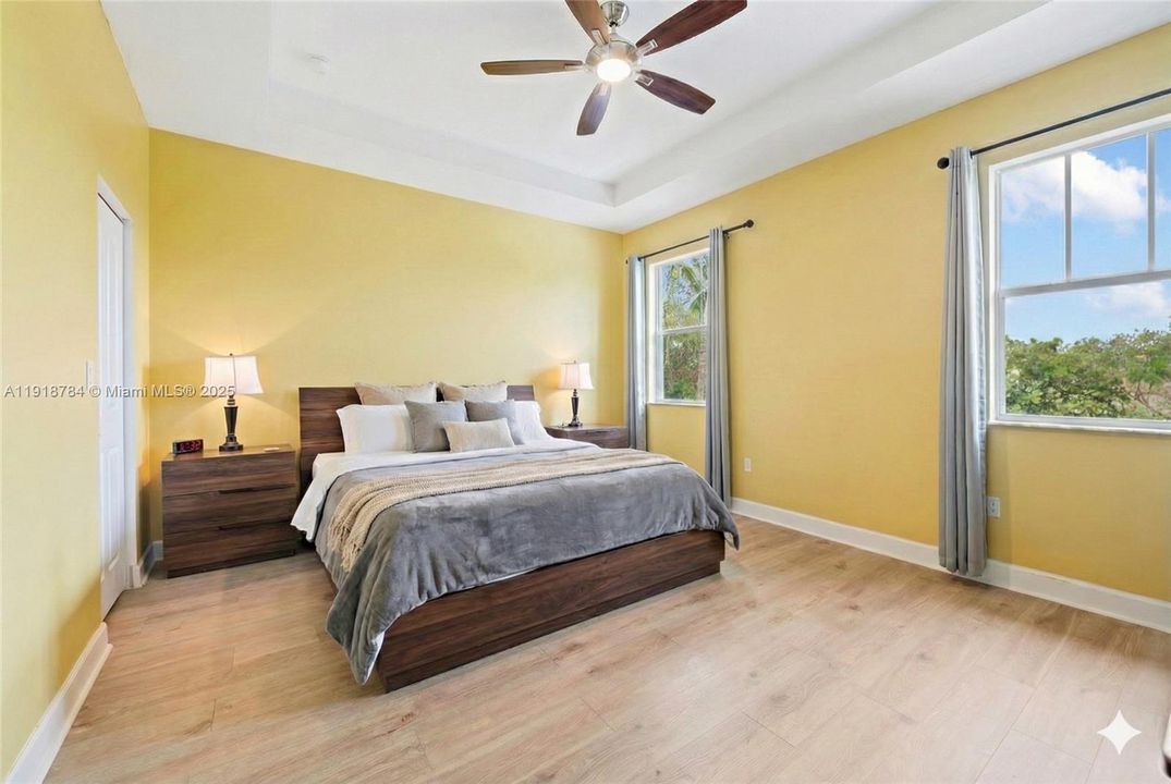 Spacious primary bedroom with excellent flow, virtually decluttered and staged for a clean and open look.