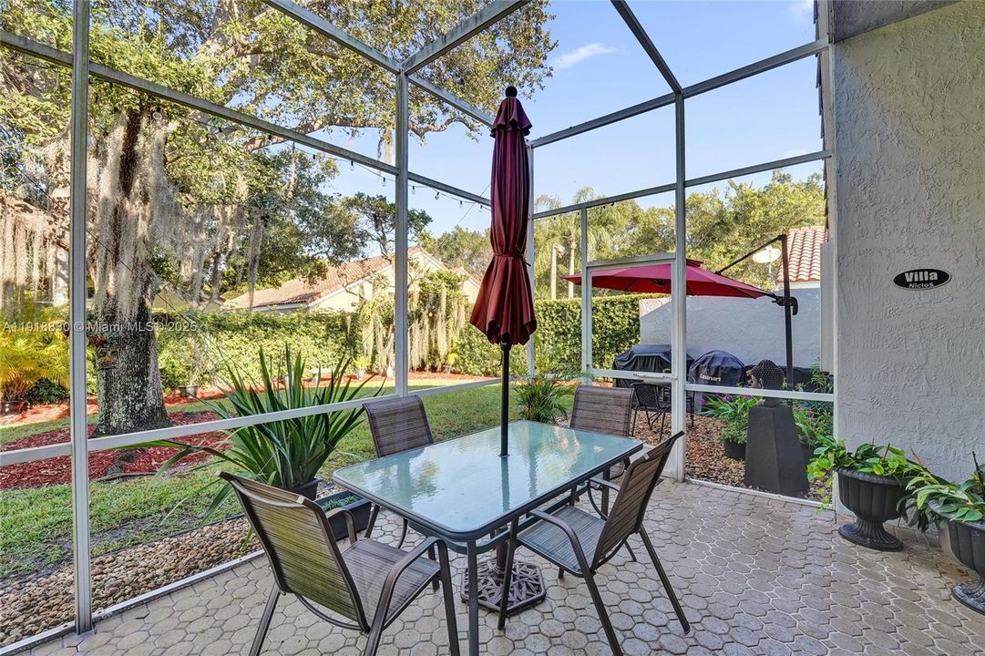 screen enclosed sunroom is shaded .   you can enjoy  a glass of wine even when it rains