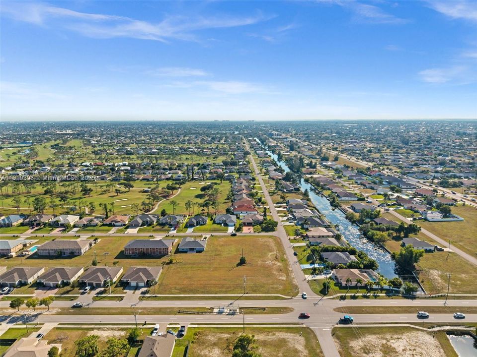 Wide aerial shot showing the surrounding neighborhood and rooftops.