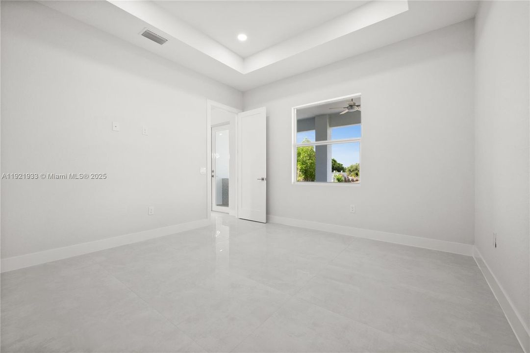 Spare room featuring a raised ceiling, light tilepatterned floors, and recessed lighting
