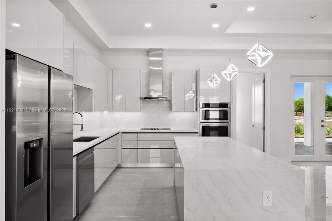 Kitchen with modern cabinets, backsplash,stainless steel appliances, light stone counters,and recessed lighting