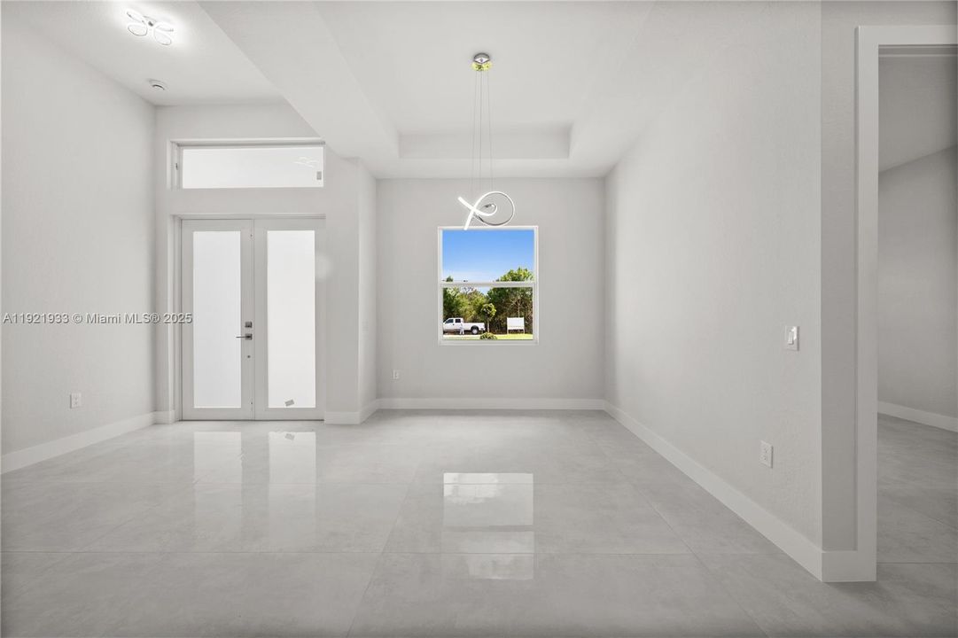 Foyer with french doors and a tray ceiling