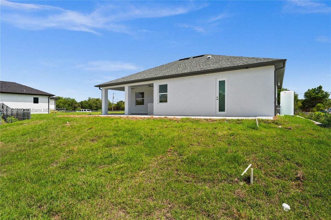 Back of house with a patio, stucco siding, ashingled roof, and ceiling fan