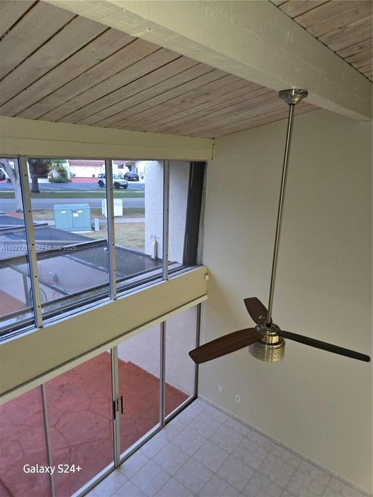 View from the second floor to living room and front patio. Cathedral wood ceilings