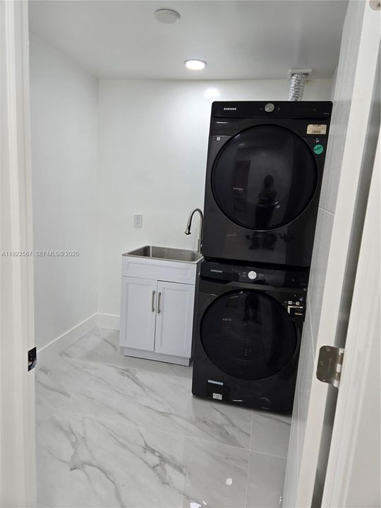 full size stackable washer and dryer plus Utility Laundry Sink. there is room for a second set of full-size stackable washer and dryer-