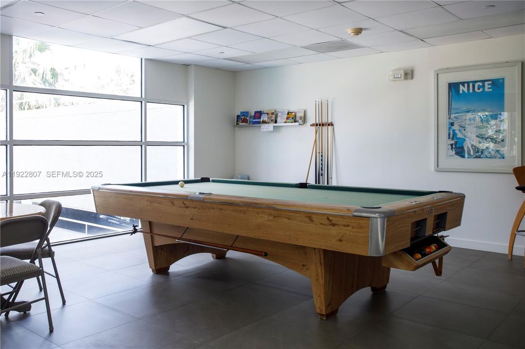 Spacious game room offering billiards, seating areas, and recreational space—perfect for residents to unwind and enjoy leisure time.