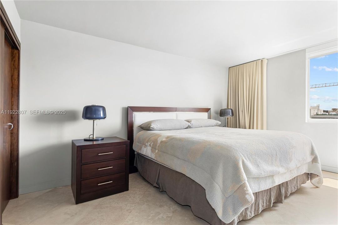 Comfortable, sun-filled bedroom with a modern layout, large window, and ample closet storage.