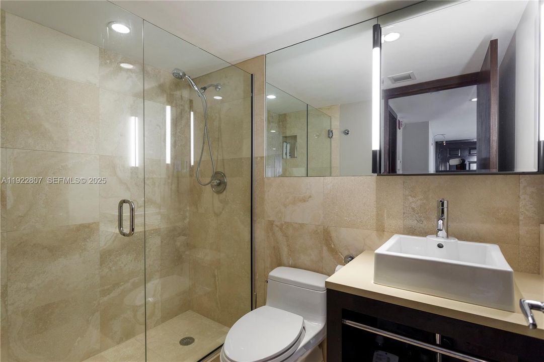 Contemporary bathroom with high-end finishes, a frameless glass shower, updated vanity, and stylish tile work.