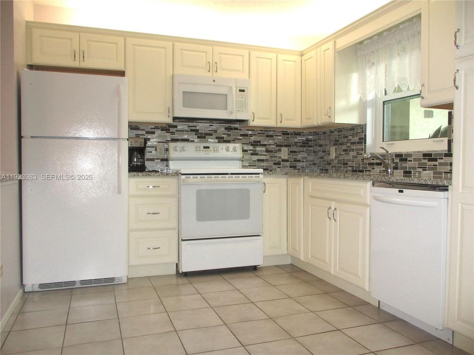 WHITE APPIANCES WITH CREAM COLORED CABINETS.