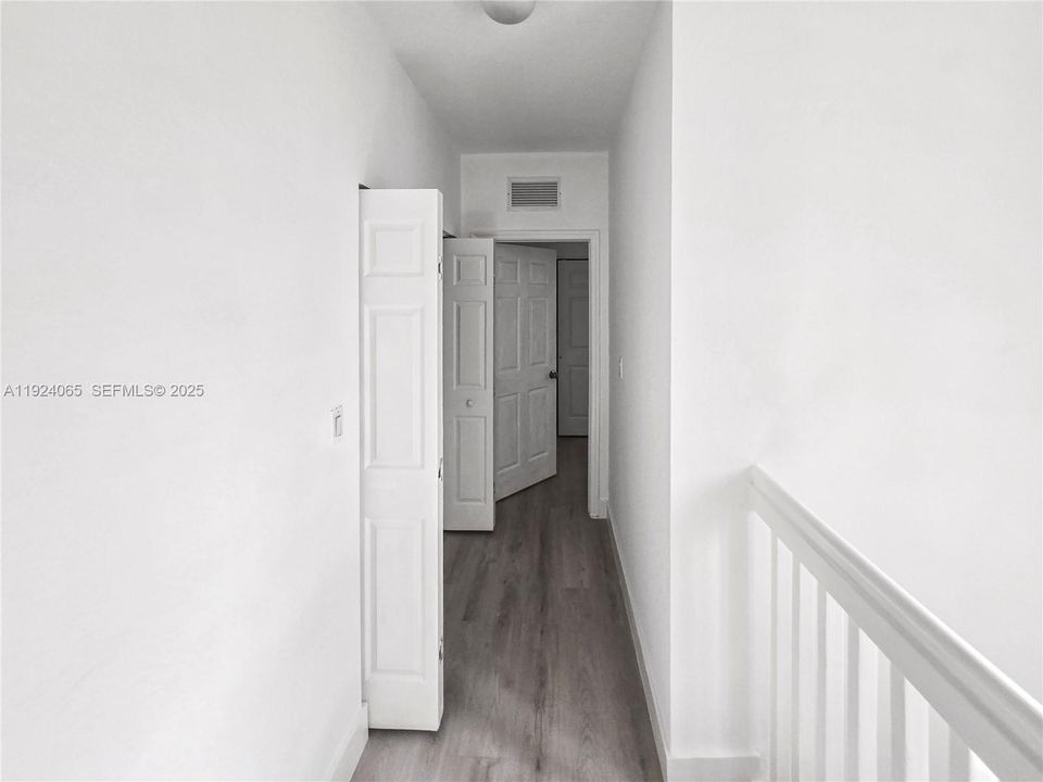Second floor hallway leading to Primary Bedroom. Laundry closet in front of Primary bedroom.