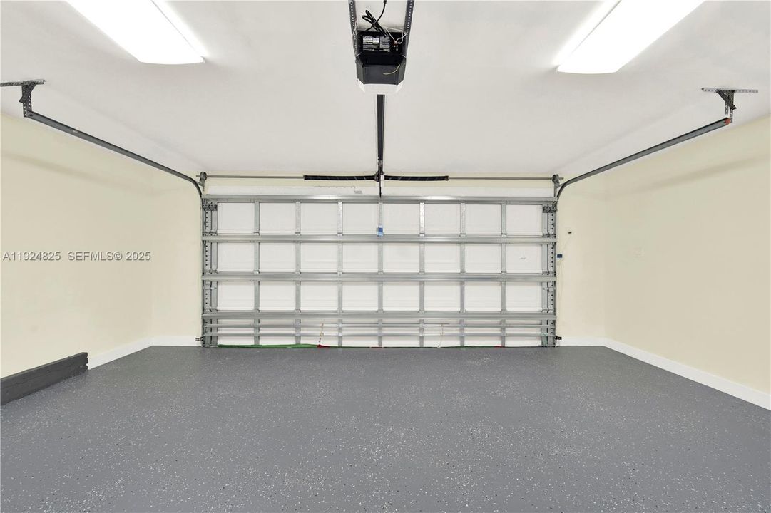 Two car garage with new epoxy floor and impact garage door in front and back.