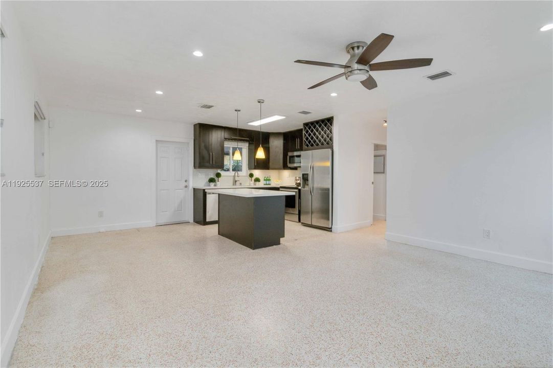 Spacious open concept living with ample natural light, remodeled kitchen, large island, quartz counter tops, elegant wood cabinets with ample storage, and stainless-steel appliance