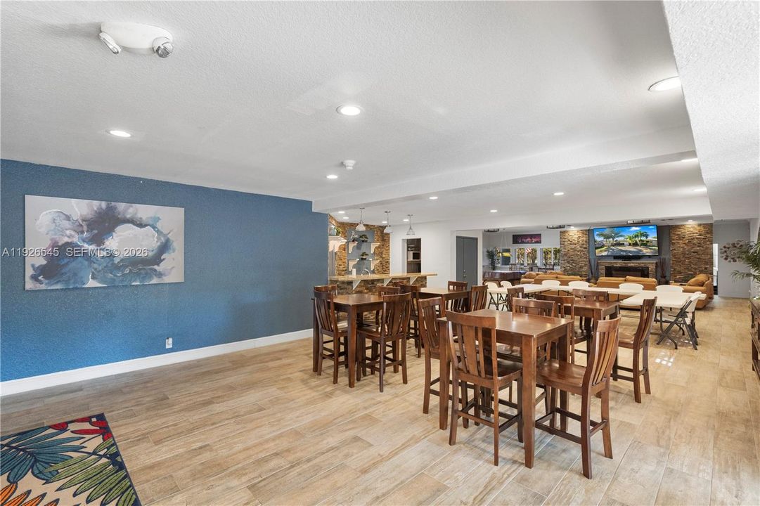 Clubhouse event room featuring tables, chairs, and a TV—perfect for hosting and celebrating.