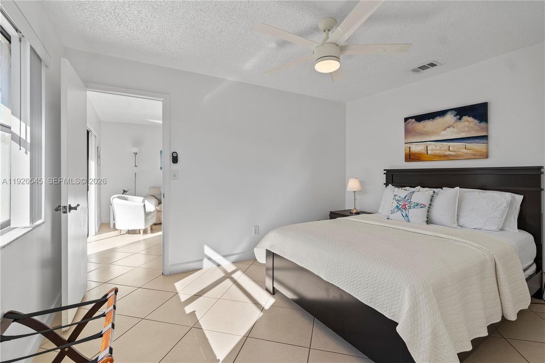 Bright primary suite next to the patio, featuring a large window and great natural light.