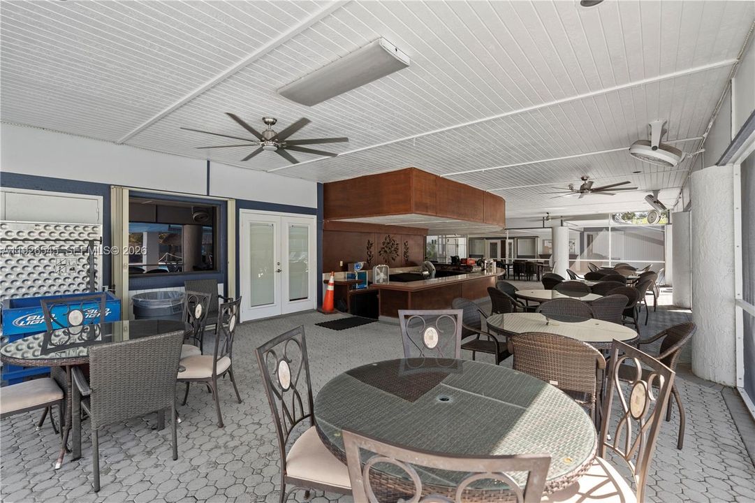 Poolside covered lounge with tables and bar-style seating perfect to relax and hang out.