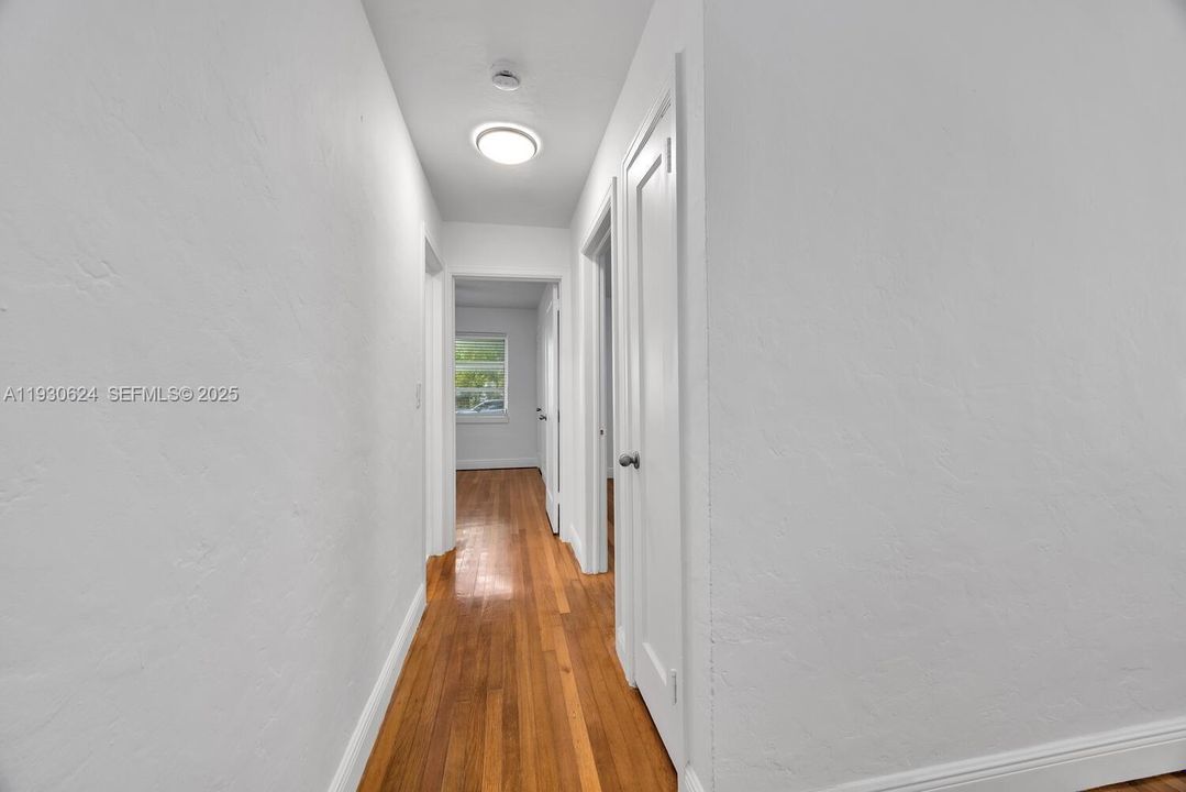 Hallway. Bathroom on the right. Both bedrooms straight ahead. Beautiful wood floors are inviting.