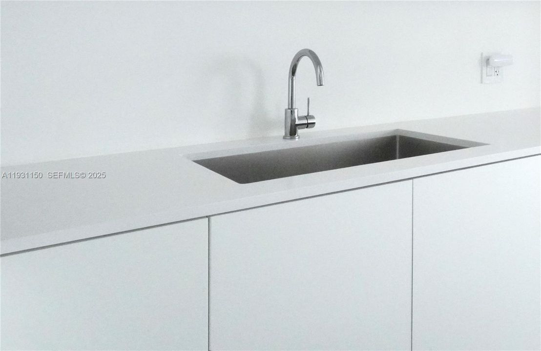White quartz countertop with deep sink.
