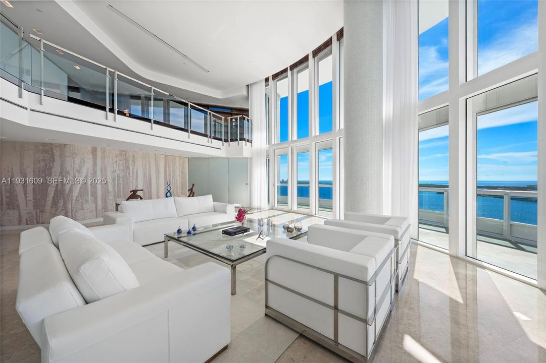 Living Room with customized mezzanine glass railing and frosted glass front door.