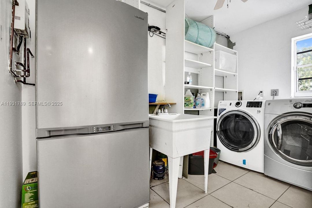 Under air laundry/utility with newer washer/dryer, sink, spare freezer/refrig.
