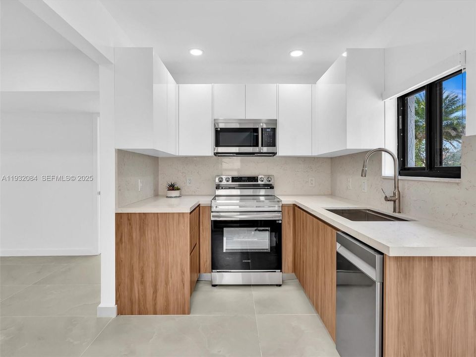 European-style kitchen with quartz counters, stainless steel appliances.