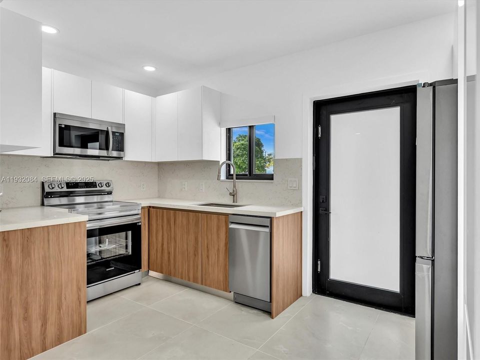 European-style kitchen with quartz counters, stainless steel appliances.