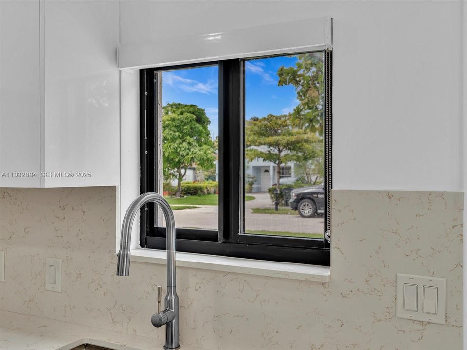 European-style kitchen with quartz counters, stainless steel appliances.