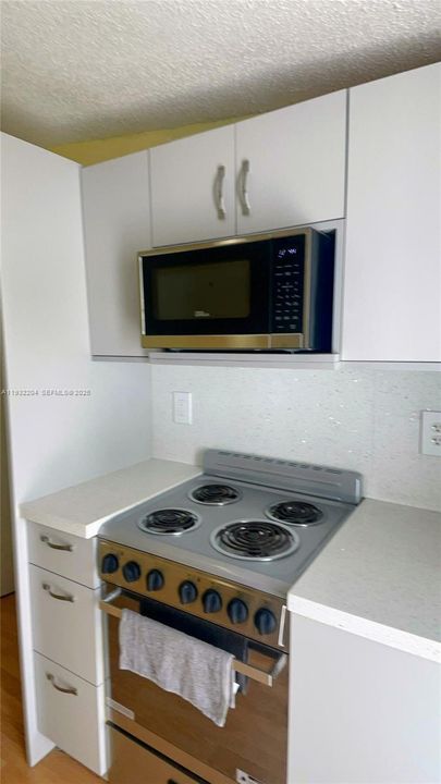 Sleek white upper and lower cabinetry with modern brushed-nickel hardware