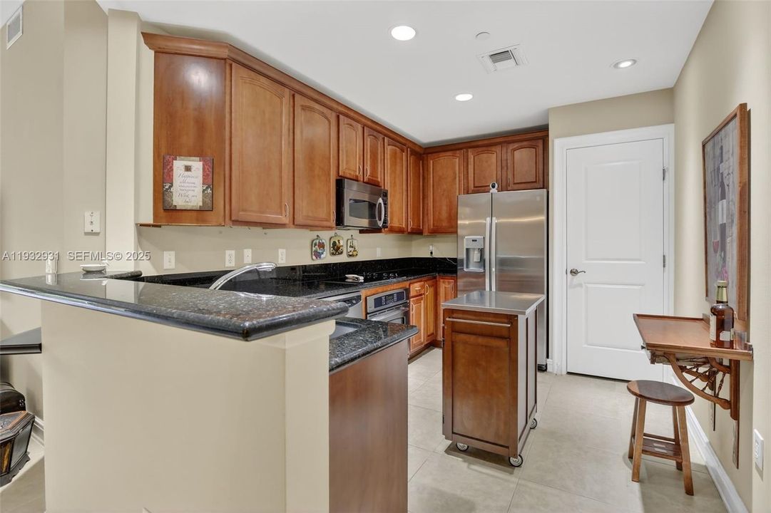 Fully upgraded kitchen with convenient rolling kitchen island which can be moved to make room for a small table and chairs.