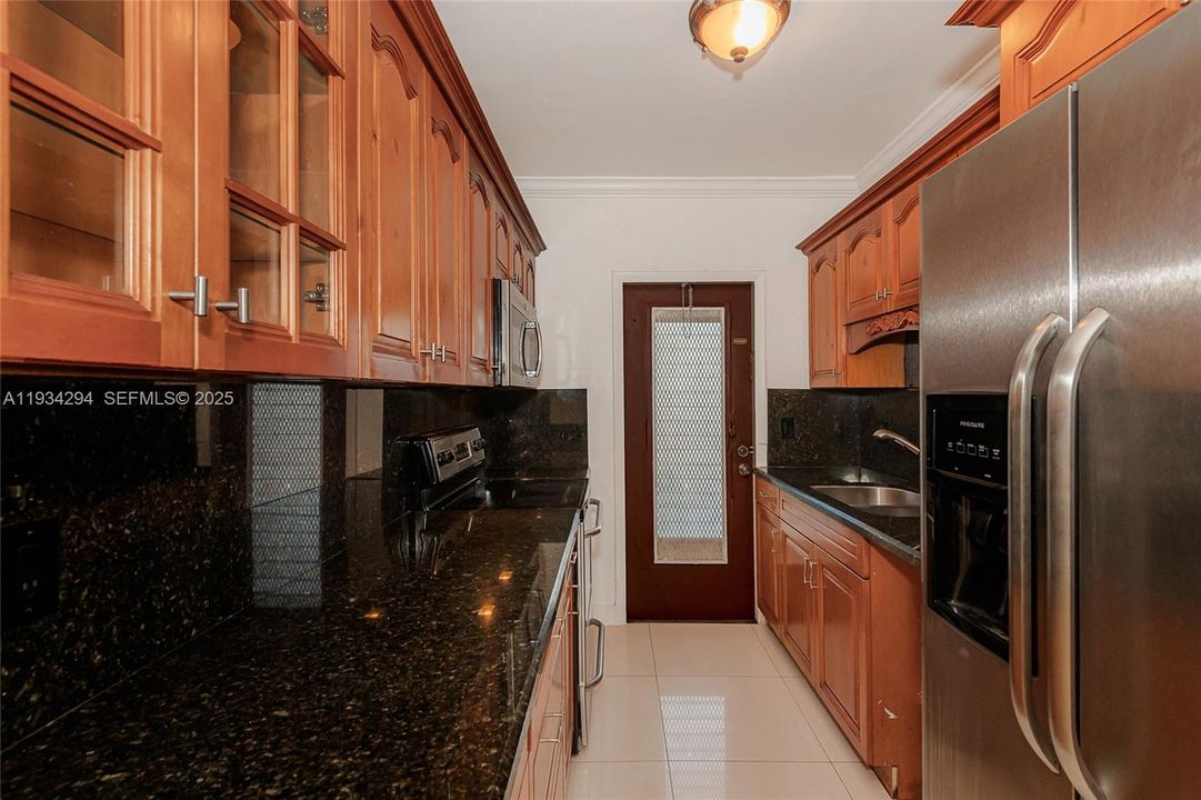 Granite counter tops, stainless steel refrigerator with water/ice in the door, beautiful wood cabinets with lots of storage space. The kitchen exit door to the outside.