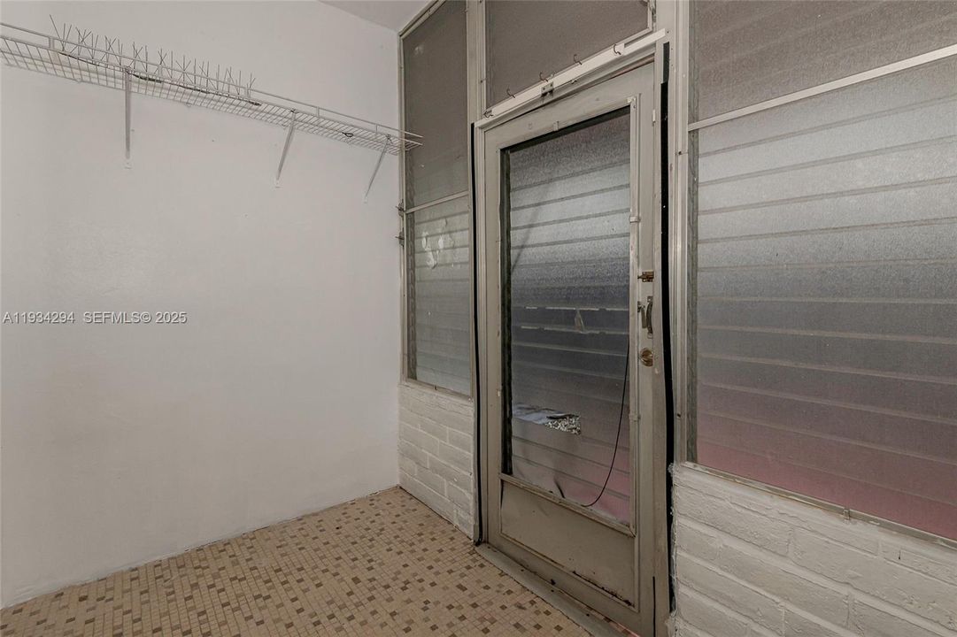 This is the enclosed porch with the door to the back patio slab outside this unit.