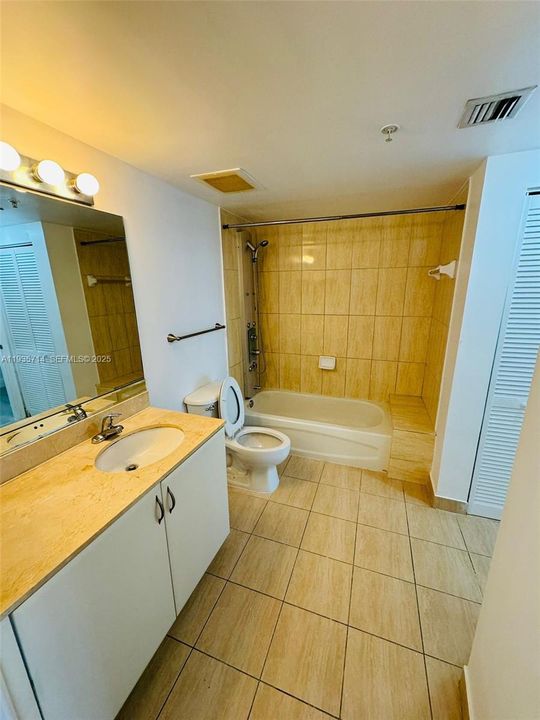 Bathroom with tub/shower combination and modern vanity.