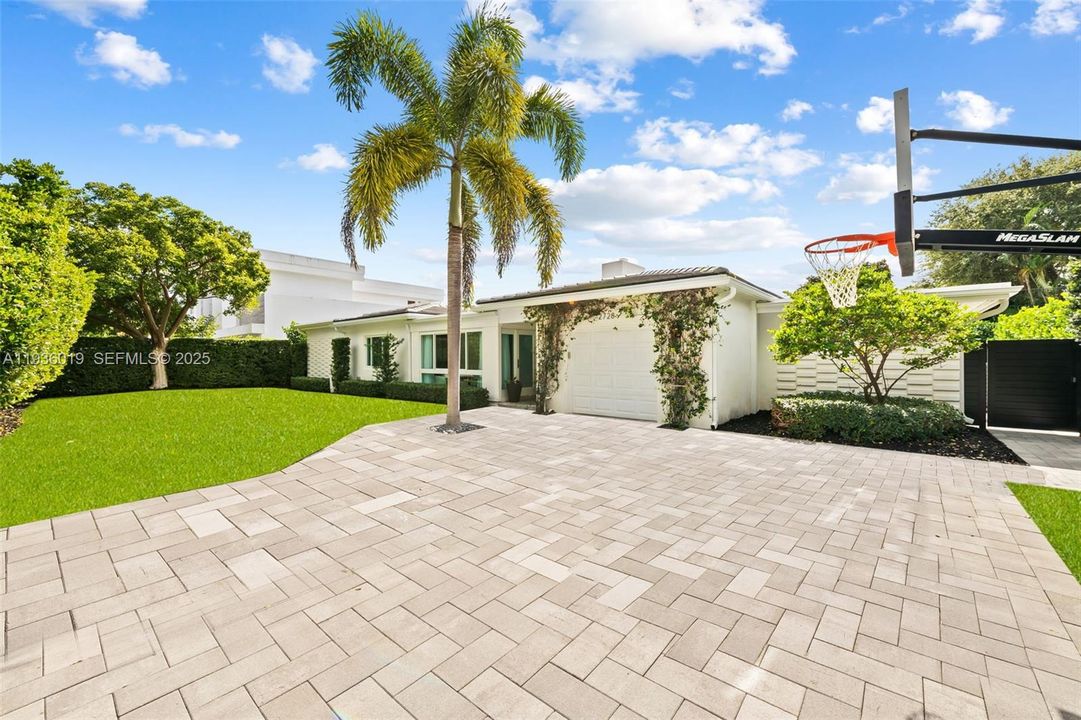 Front elevation featuring pavered driveway and 1 car garage