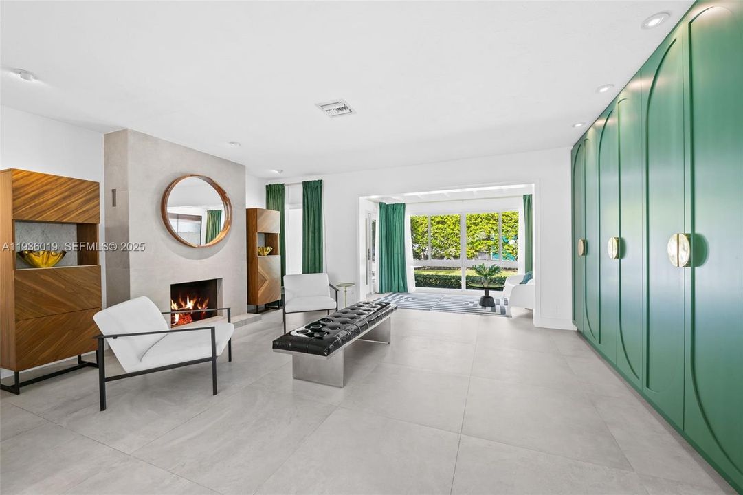 View from kitchen to formal living & foyer. Featuring fire place and custom cabinetry.