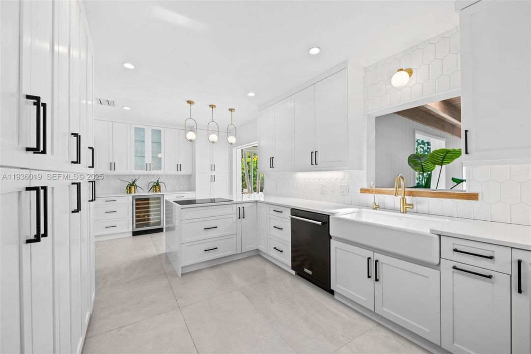 Custom kitchen featuring induction stove and built in wine cooler