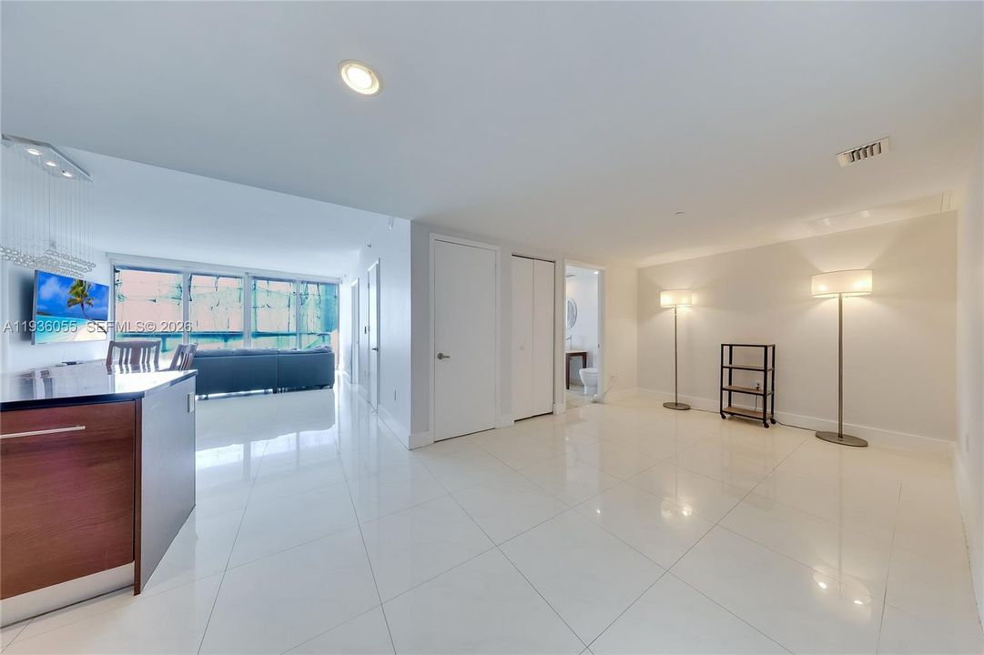 This area is a den area off the kitchen. It could be closed off, it shares a bathroom with the guest bedroom on the opposite side. Windows have protective film due to construction work.