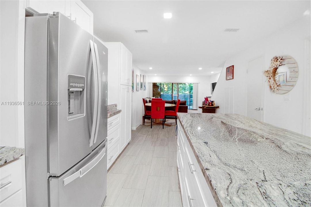 Looking north through property, dining area, then living area, then private balcony.