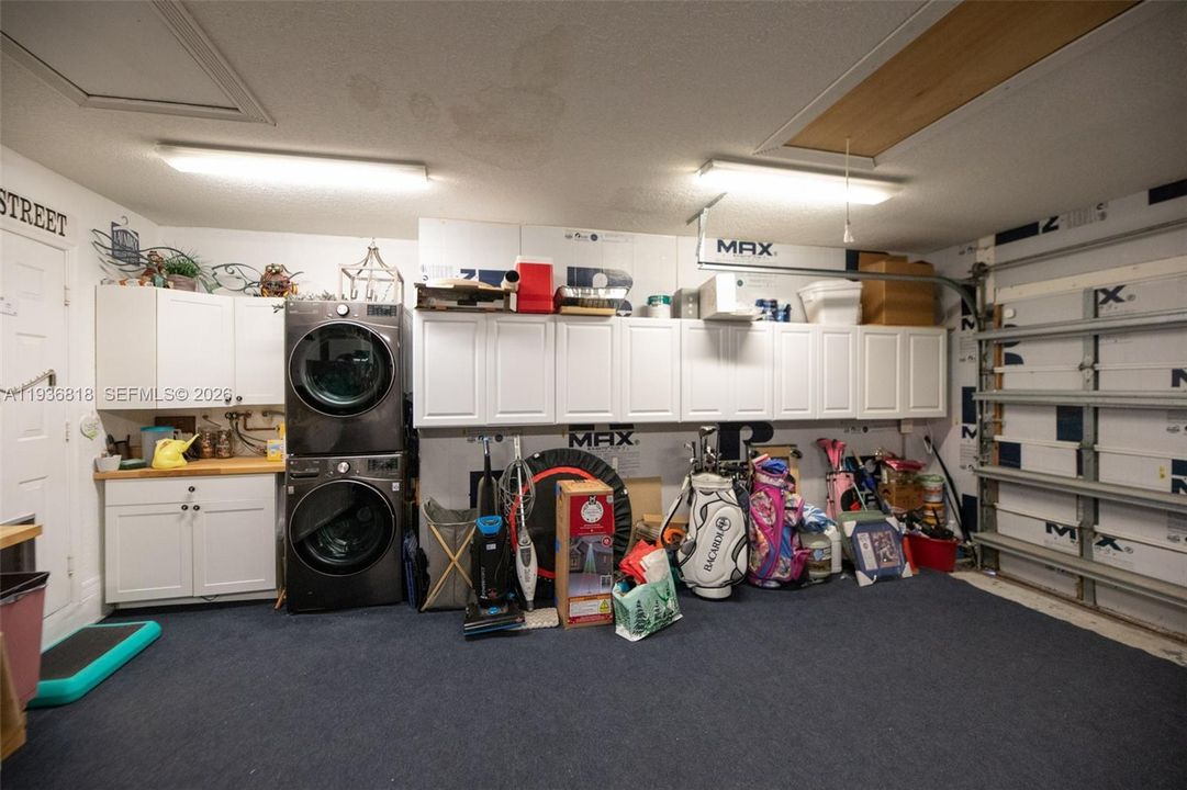 Plenty of Garage cabinets w pull down attic ladder that also has a large storage space