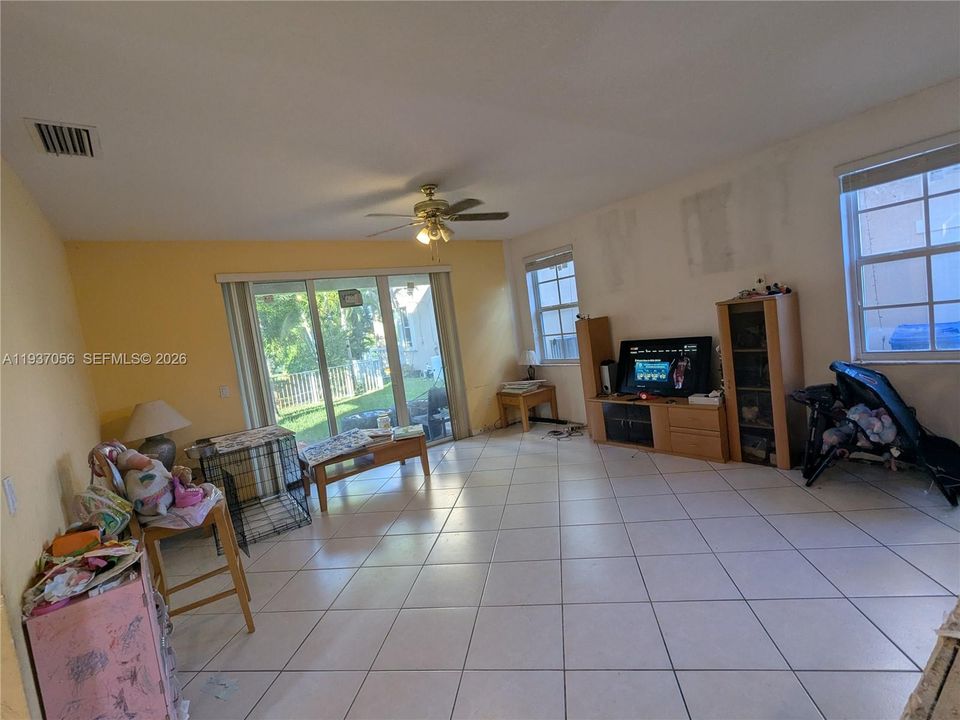 Bright family room featuring a ceiling fan and an inviting open layout