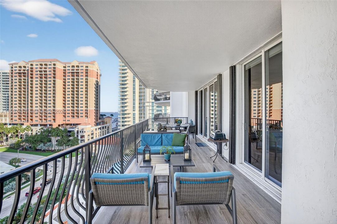 Long Balcony w/ new plank tile flooring. 3 sets of slides lead to balcony, from Family Rm, Guest Rm & Primary Bedroom