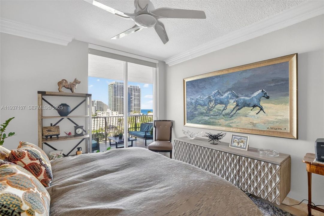 Guest bedroom (2nd primary bedroom) w/ sliders off to the balcony and ocean views & motorized window roller shade.