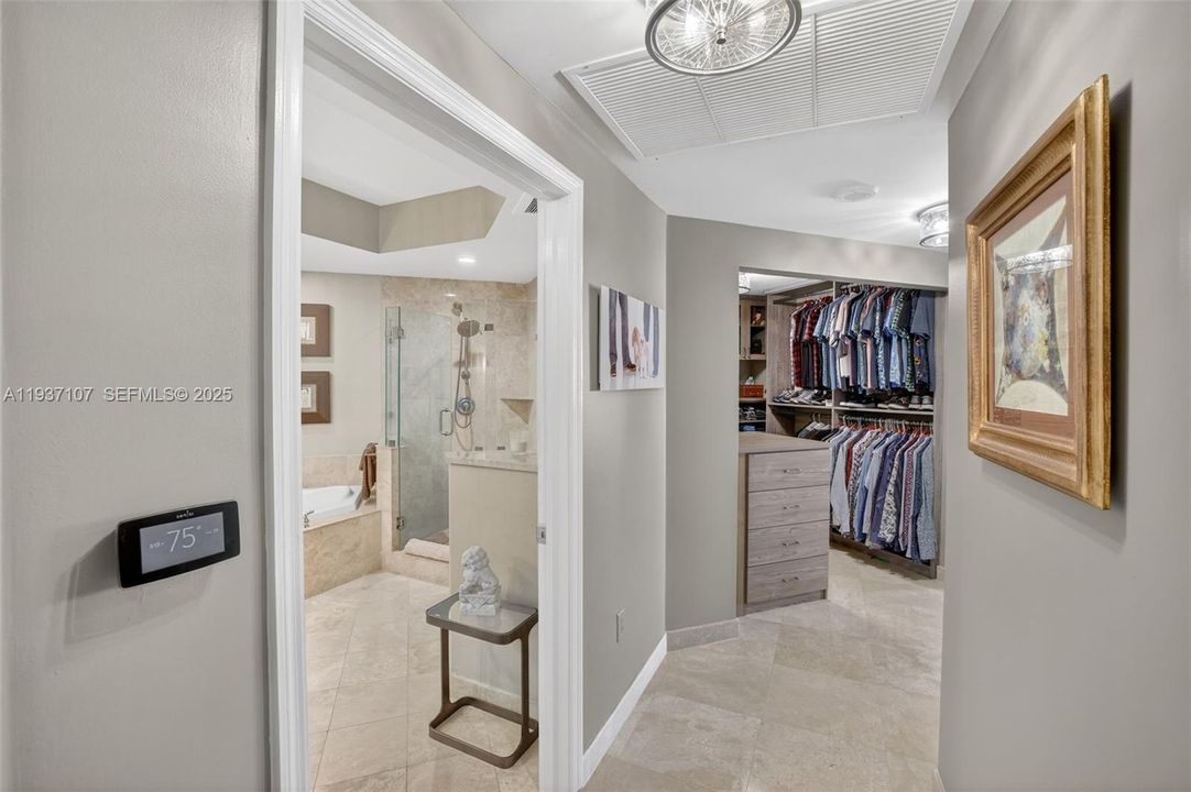 View toward primary closet and bathroom. Wifi thermostat.