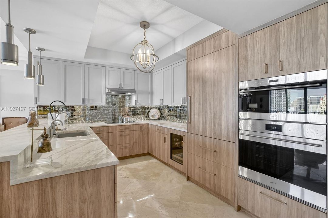 Spectacular kitchen w/ custom bleached walnut veneer cabinetry by renowned Chicago based millworker. Grain matches from top to bottom. Taj mahal quartzite. Wolf induction cooktop & double oven (w/ microwave / convenction at top oven), Sub Zero Refrigerator & Beverage Cooler, Miele Dishwasher.  Sink w/ touchless Brizo faucet, including water filtration faucet. Antiqued mirror backsplash
