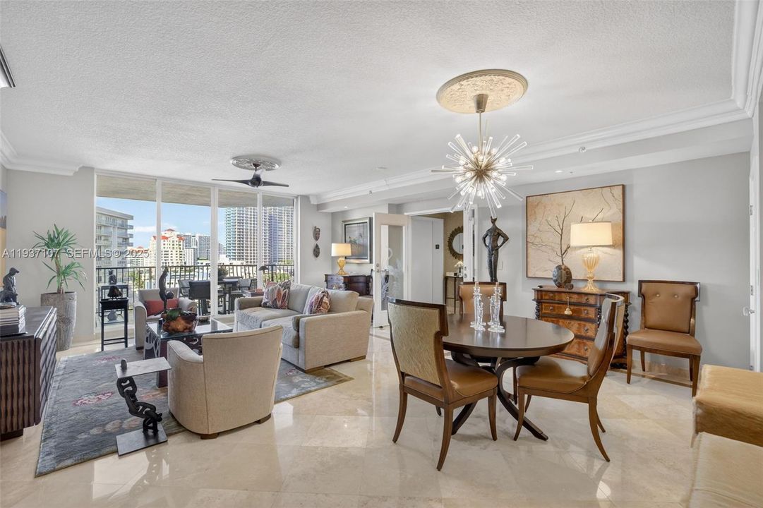 Beautiful sputnik chandelier, Emtek crystal door hardware throughout unit, counter seating at kitchen. Crown molding. Open Concept living. Bright natural light. Floor to ceiling glass. Foyer from semi-private elevator. Art lighting over two paintings by foyer.