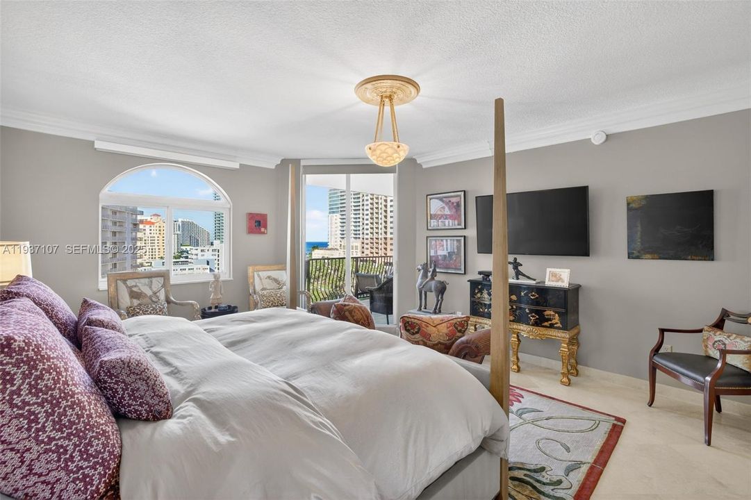 Primary bedroom w/ beautiful views of intracoastal and to balcony and ocean. Motorized window treatments. Chandelier does not convey.