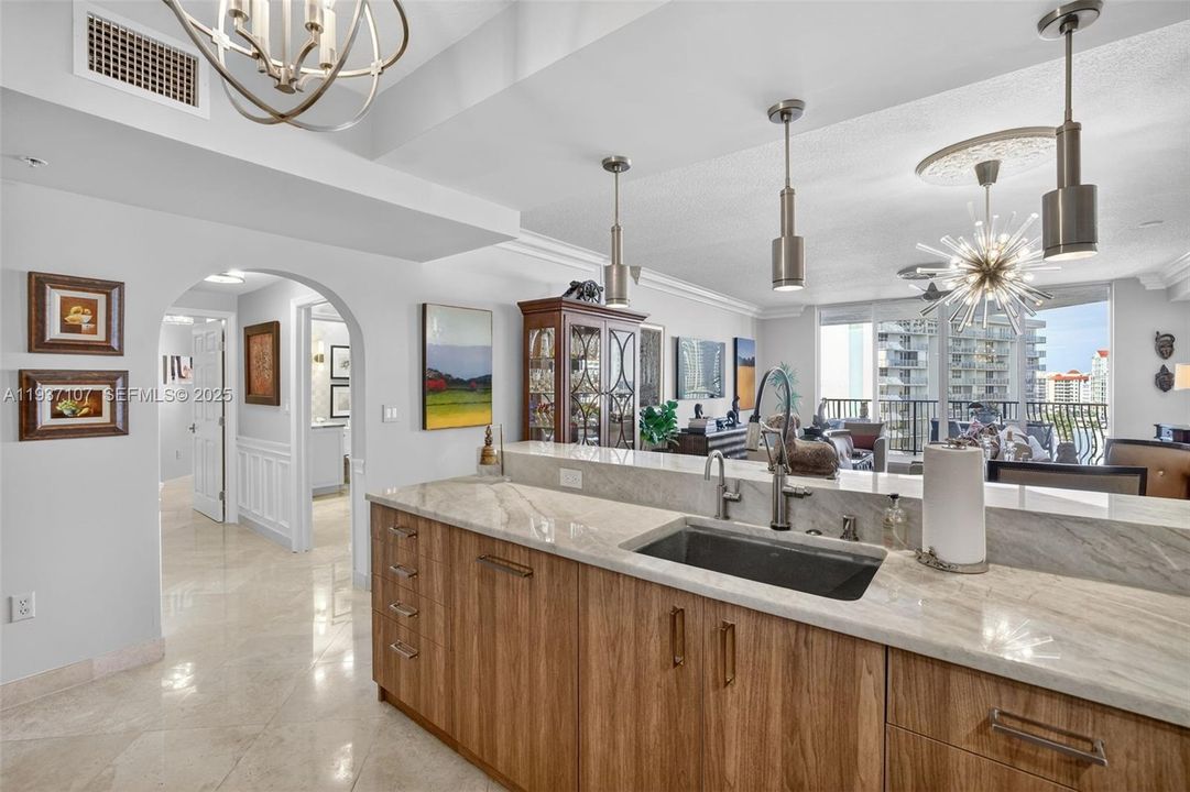 Spectacular kitchen w/ custom bleached walnut veneer cabinetry by renowned Chicago based millworker. Grain matches from top to bottom. Taj mahal quartzite. Wolf induction cooktop & double oven (w/ microwave / convenction at top oven), Sub Zero Refrigerator & Beverage Cooler, Miele Dishwasher.  Sink w/ touchless Brizo faucet, including water filtration faucet. Antiqued mirror backsplash