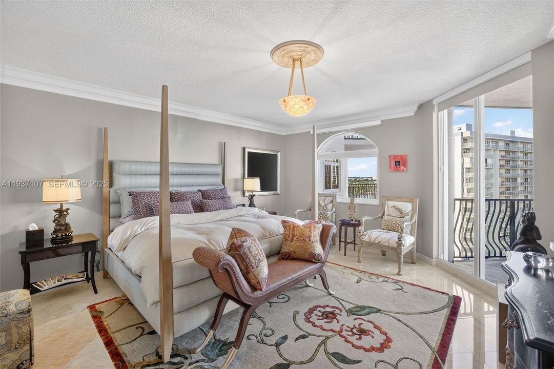 Primary bedroom w/ beautiful views of intracoastal and to balcony and ocean. Motorized window treatments. Chandelier does not convey.