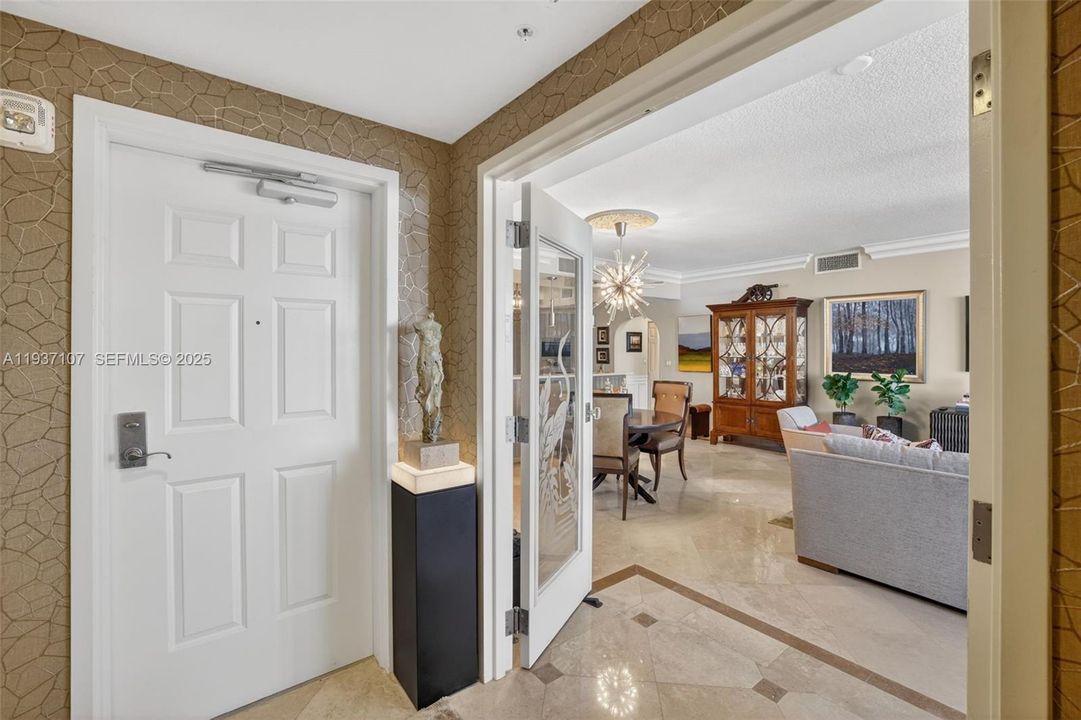 Foyer entry coming off the semi-private elevator w/ beautiful wall coverings. Door in front takes you to back hallway w/ trash chute, mechanical closets & additional elevators. Elevator takes you to custom double doors and into bright luxury condo