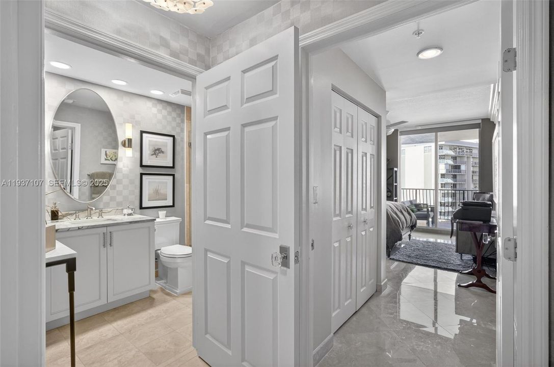 Secondary primary bedroom (guest room) w/ en suite bathroom and closet w/ upgraded door hardware. Emtek crystal door hardware. Bathroom w/ designer wall coverings, custom vanity, upgraded Kohler toilet. Double door entry for bedroom so bathroom acts as guest bathroom, or en suite bathroom.