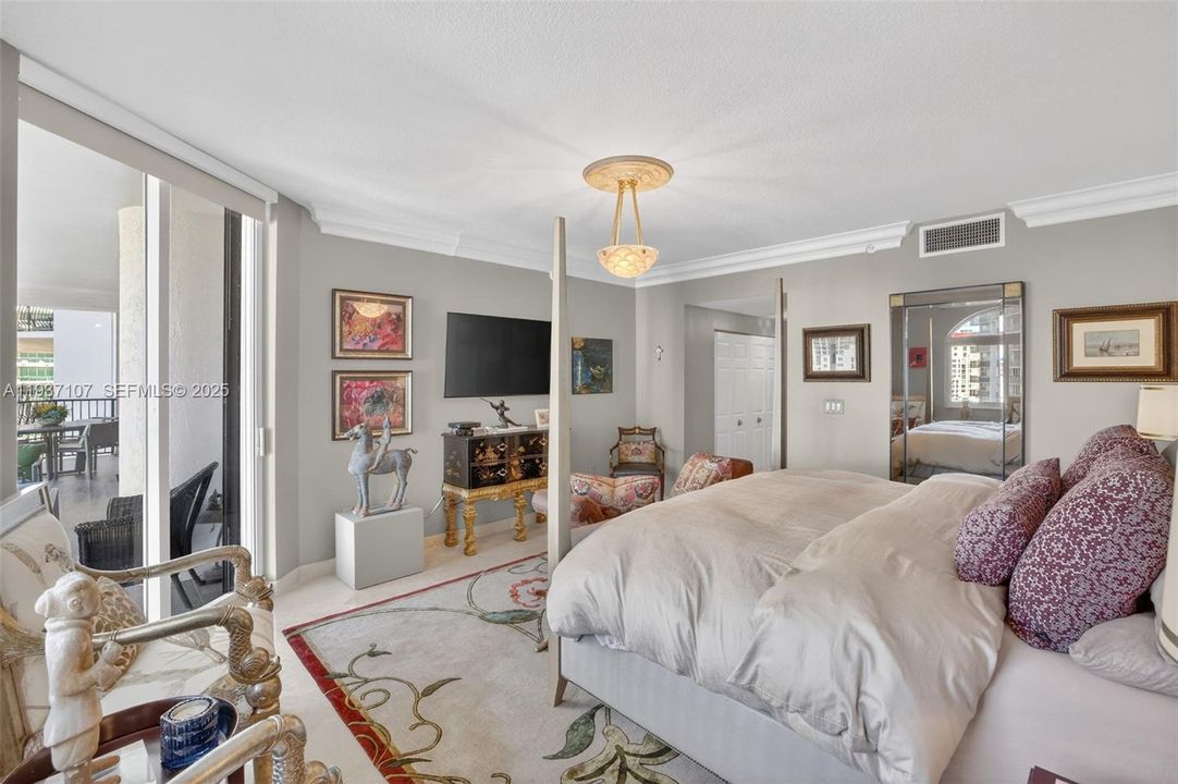 Large primary bedroom w/ motorized room blackout shades and sitting area